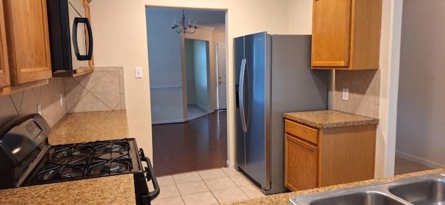 2902 Winslow Forest Ln, Houston, TX 77047 - kitchen featuring black appliances, decorative backsplash, light countertops, and brown cabinetry