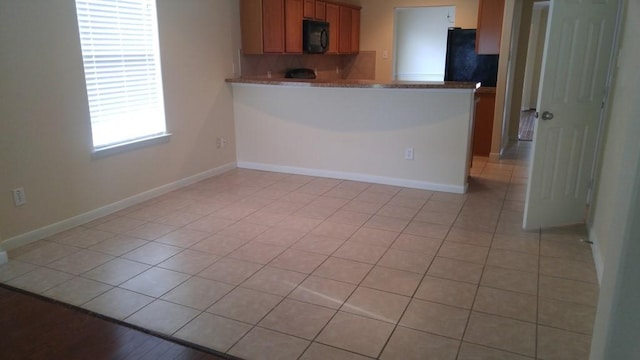 2902 Winslow Forest Ln, Houston, TX 77047 - kitchen with black appliances, decorative backsplash, light tile patterned floors, and baseboards
