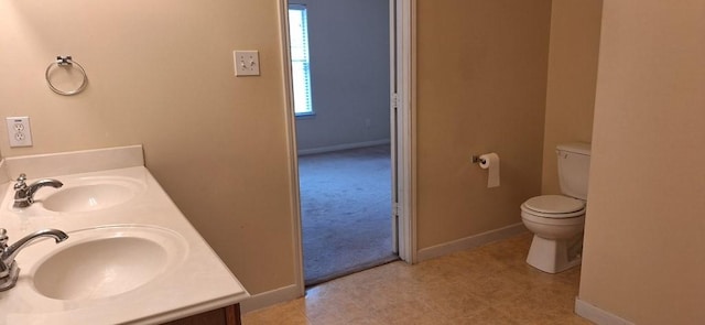 2902 Winslow Forest Ln, Houston, TX 77047 - bathroom featuring toilet, double vanity, and baseboards