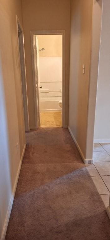 2902 Winslow Forest Ln, Houston, TX 77047 - corridor featuring baseboards, light tile patterned floors, and light carpet