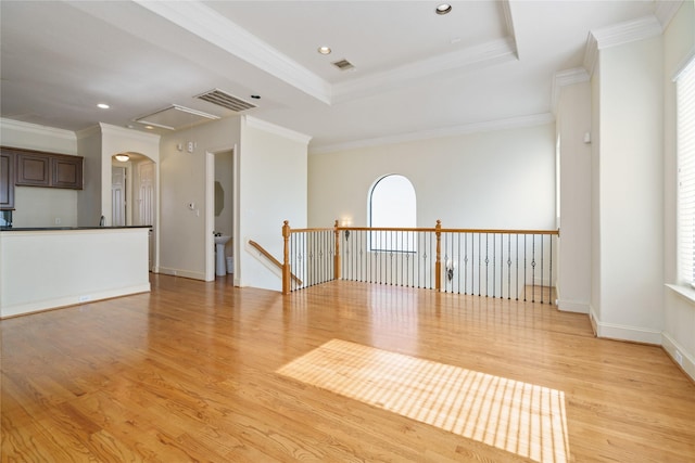 311 Gregg St, Houston, TX 77020 - unfurnished room featuring light wood-style floors, attic access, plenty of natural light, arched walkways, and crown molding