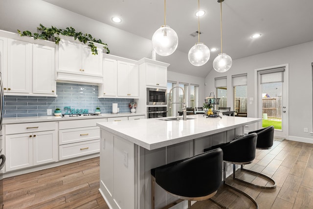 4107 Maple Glen Dr, Fulshear, TX 77441 - kitchen with a sink, light wood-style flooring, light countertops, stainless steel appliances, and decorative backsplash