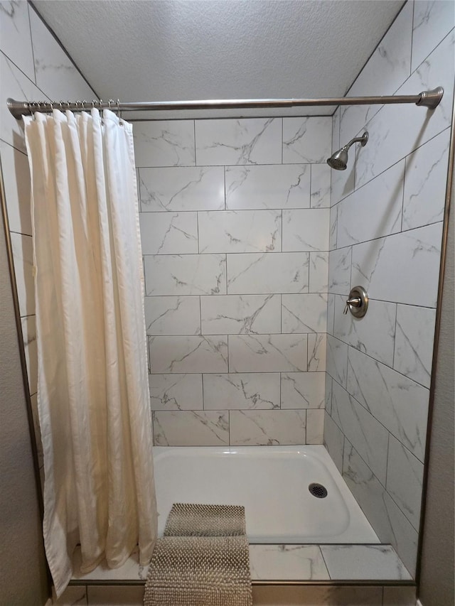 263 Kingfish Ln, Palacios, TX 77465 - bathroom with a textured ceiling and tiled shower