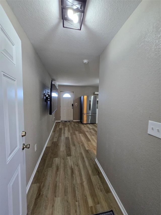 263 Kingfish Ln, Palacios, TX 77465 - corridor with wood finished floors, baseboards, and a textured ceiling