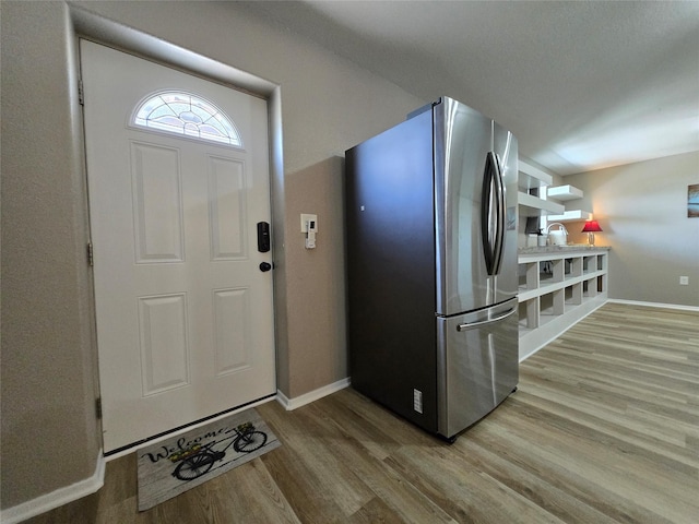 263 Kingfish Ln, Palacios, TX 77465 - kitchen with freestanding refrigerator, light wood finished floors, and baseboards