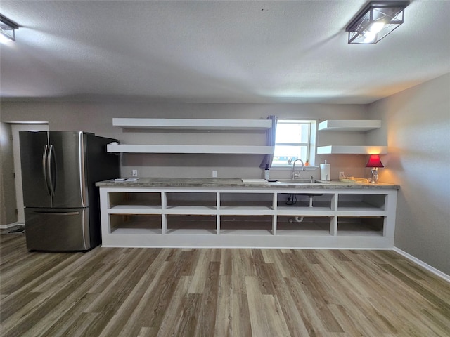 263 Kingfish Ln, Palacios, TX 77465 - kitchen featuring open shelves, freestanding refrigerator, wood finished floors, and a textured ceiling