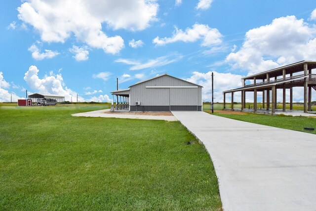 263 Kingfish Ln, Palacios, TX 77465 - view of home's community with a lawn, driveway, an outdoor structure, and an outbuilding