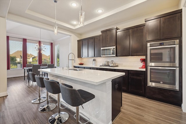 19534 Juniper Breeze Ln, Spring, TX 77379 - kitchen featuring a sink, appliances with stainless steel finishes, backsplash, light wood finished floors, and recessed lighting