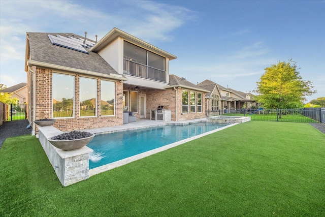 19534 Juniper Breeze Ln, Spring, TX 77379 - back of property featuring brick siding, roof with shingles, roof mounted solar panels, and a pool with connected hot tub