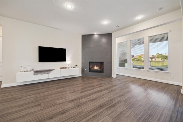 19534 Juniper Breeze Ln, Spring, TX 77379 - unfurnished living room featuring wood finished floors, baseboards, a tile fireplace, and recessed lighting