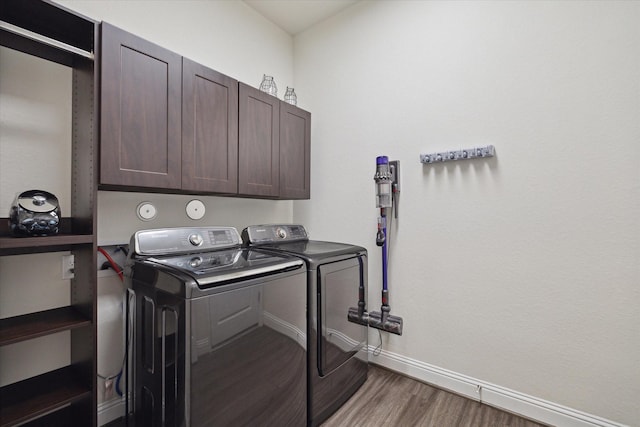 19534 Juniper Breeze Ln, Spring, TX 77379 - laundry room with washing machine and dryer, wood finished floors, cabinet space, and baseboards