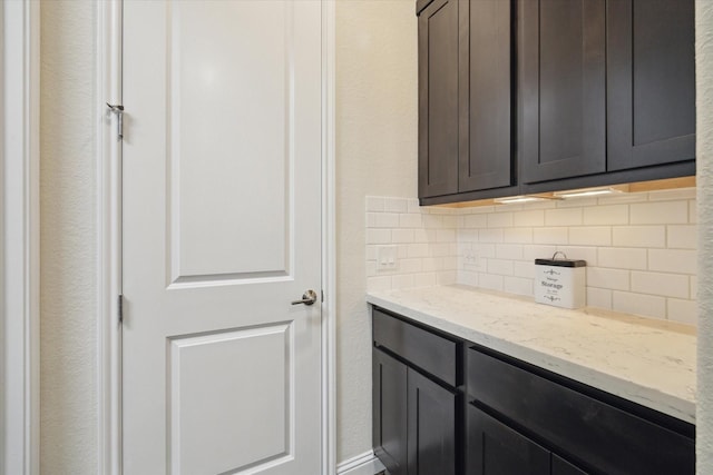 19534 Juniper Breeze Ln, Spring, TX 77379 - kitchen with backsplash, light stone counters, and a textured wall
