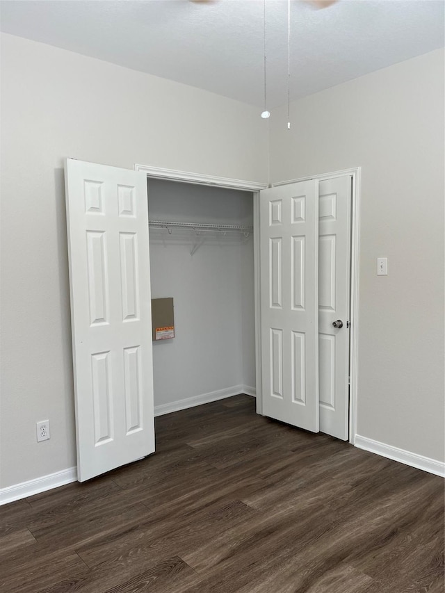 2702 Orchard Creek Ln, Katy, TX 77494 - unfurnished bedroom featuring dark wood-style floors, a closet, and baseboards
