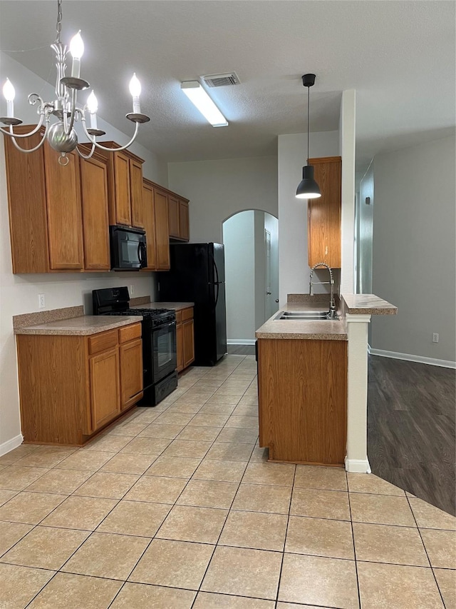 2702 Orchard Creek Ln, Katy, TX 77494 - kitchen with black appliances, arched walkways, a sink, brown cabinets, and baseboards