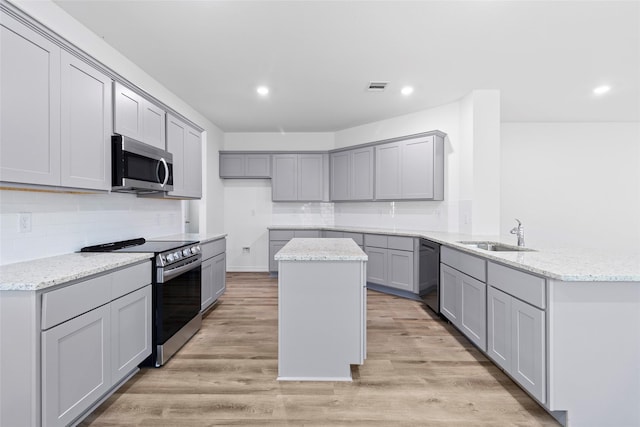 12672 Lake Conroe Hls, Conroe, TX 77318 - kitchen featuring appliances with stainless steel finishes, gray cabinets, a peninsula, tasteful backsplash, and recessed lighting