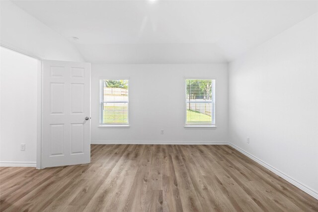 12672 Lake Conroe Hls, Conroe, TX 77318 - empty room featuring vaulted ceiling, light wood-type flooring, and healthy amount of natural light