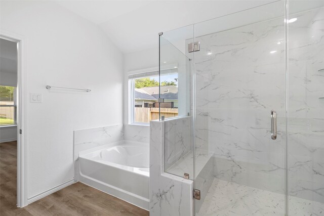12672 Lake Conroe Hls, Conroe, TX 77318 - bathroom featuring a garden tub, vaulted ceiling, a marble finish shower, and wood finished floors