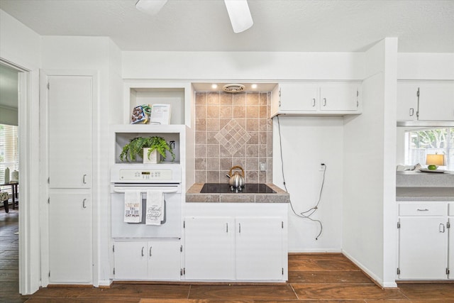 5939 Rutherglenn Dr, Houston, TX 77096 - kitchen with white oven, white cabinetry, tasteful backsplash, dark wood-style floors, and open shelves