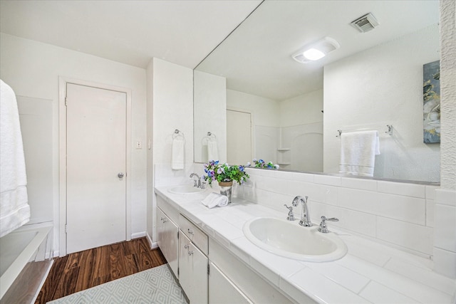 5939 Rutherglenn Dr, Houston, TX 77096 - full bath featuring wood finished floors, double vanity, a bath, and backsplash