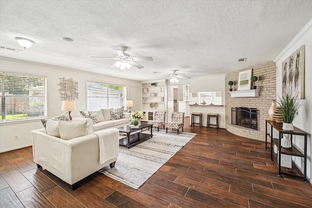 5939 Rutherglenn Dr, Houston, TX 77096 - living area with dark wood-type flooring, a textured ceiling, a ceiling fan, a brick fireplace, and baseboards