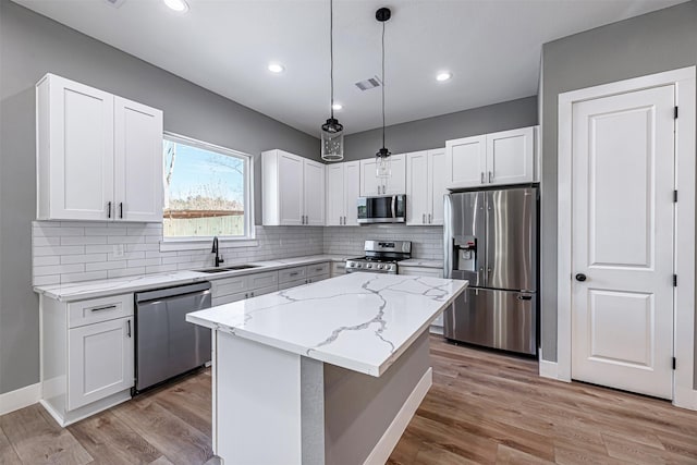 2020 Wavell St, Houston, TX 77088 - kitchen with stainless steel appliances, a sink, light stone countertops, white cabinets, and recessed lighting