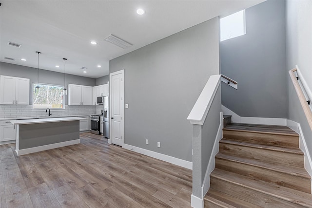2020 Wavell St, Houston, TX 77088 - kitchen with appliances with stainless steel finishes, light countertops, white cabinetry, decorative backsplash, and a sink