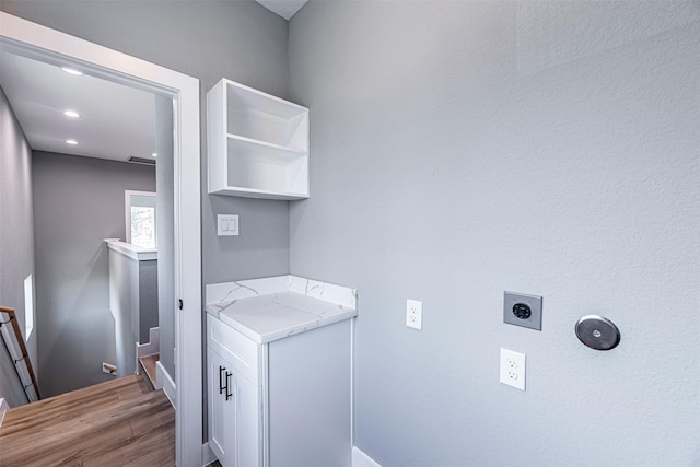 2020 Wavell St, Houston, TX 77088 - laundry area featuring electric dryer hookup, wood finished floors, and baseboards