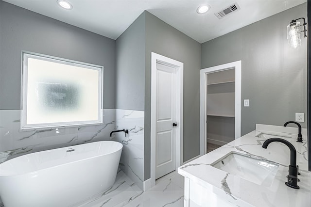2020 Wavell St, Houston, TX 77088 - full bath featuring a soaking tub, double vanity, recessed lighting, marble finish floors, and a closet