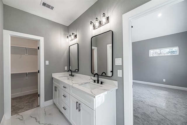 2020 Wavell St, Houston, TX 77088 - bathroom featuring baseboards, double vanity, marble look tile flooring, and a walk in closet