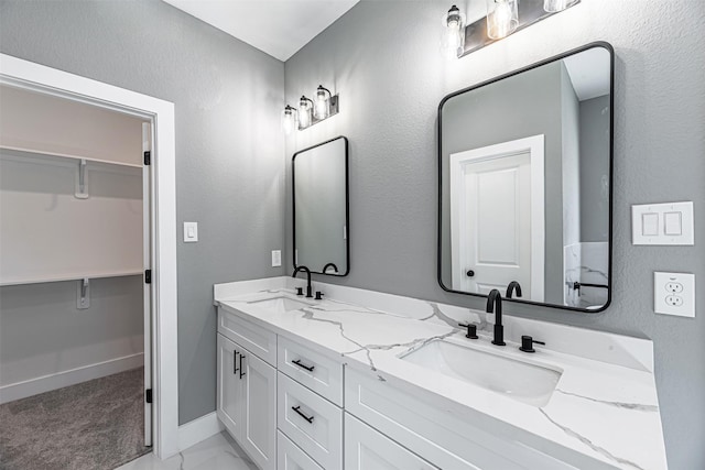 2020 Wavell St, Houston, TX 77088 - bathroom featuring double vanity, a walk in closet, and baseboards