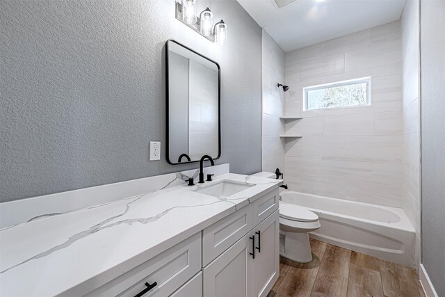 2020 Wavell St, Houston, TX 77088 - bathroom featuring wood finished floors, toilet, vanity, shower / bathtub combination, and a textured wall