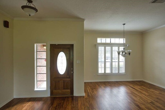 108 Madison Ave, Clute, TX 77531 - foyer entrance featuring a chandelier, wood finished floors, baseboards, ornamental molding, and a textured ceiling