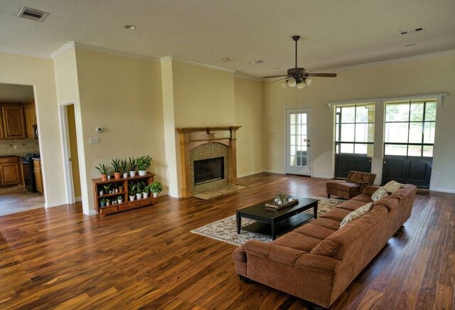 108 Madison Ave, Clute, TX 77531 - living room with a high end fireplace, a ceiling fan, wood finished floors, ornamental molding, and baseboards