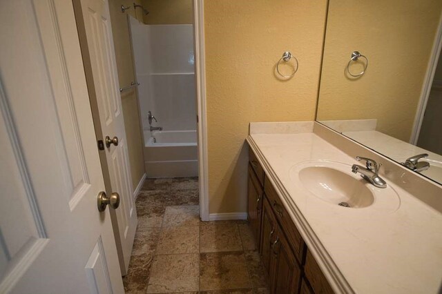 108 Madison Ave, Clute, TX 77531 - full bath featuring vanity,  shower combination, baseboards, and stone finish flooring