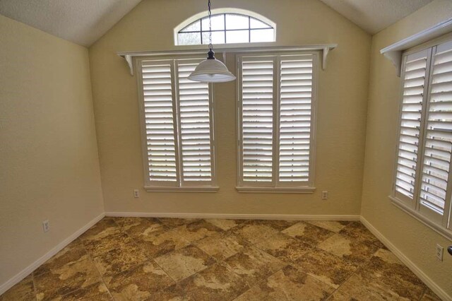 108 Madison Ave, Clute, TX 77531 - unfurnished dining area featuring vaulted ceiling, baseboards, and healthy amount of natural light