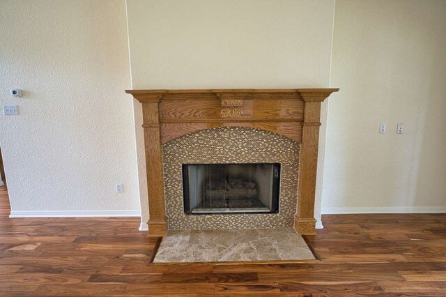 108 Madison Ave, Clute, TX 77531 - detailed view of wood finished floors, baseboards, and a tiled fireplace