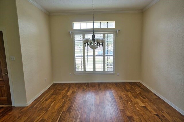 108 Madison Ave, Clute, TX 77531 - unfurnished dining area featuring a chandelier, dark wood-type flooring, baseboards, ornamental molding, and a textured wall