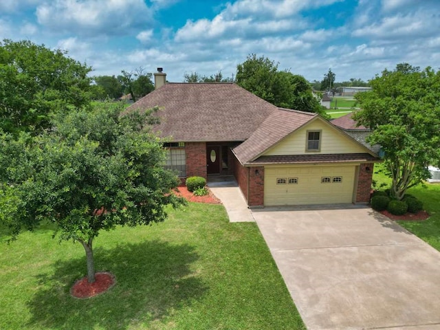 108 Madison Ave, Clute, TX 77531 - view of front facade with brick siding, driveway, a front yard, and an attached garage