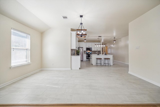 9907 Channel Set Way, Rosharon, TX 77583 - unfurnished living room featuring a chandelier and baseboards