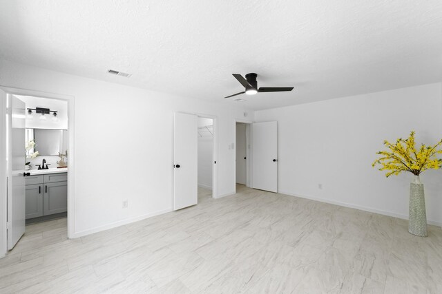 7511 Londres Dr, Houston, TX 77083 - unfurnished bedroom featuring a spacious closet, ensuite bathroom, ceiling fan, a closet, and a sink