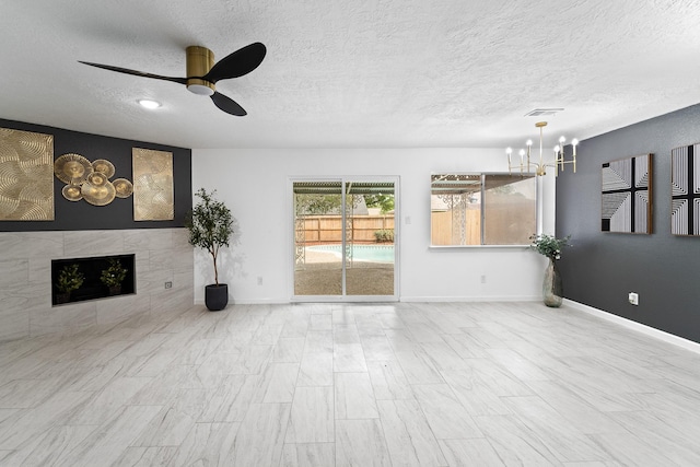 7511 Londres Dr, Houston, TX 77083 - unfurnished living room with a ceiling fan, a chandelier, a textured ceiling, a tile fireplace, and baseboards