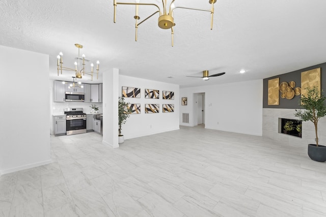 7511 Londres Dr, Houston, TX 77083 - unfurnished living room with a chandelier, a large fireplace, a textured ceiling, and a ceiling fan