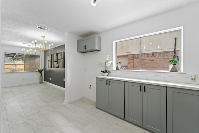 7511 Londres Dr, Houston, TX 77083 - bar area with a chandelier, light marble finish floors, hanging light fixtures, and baseboards
