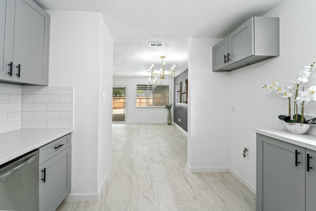7511 Londres Dr, Houston, TX 77083 - kitchen with gray cabinetry, stainless steel dishwasher, light marble finish floors, decorative backsplash, and light countertops