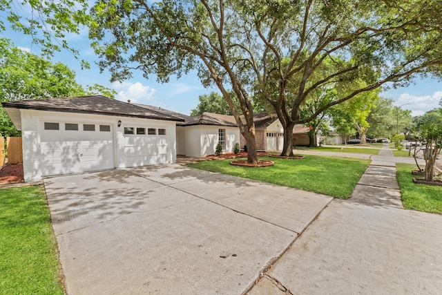 7511 Londres Dr, Houston, TX 77083 - view of front facade with concrete driveway, an attached garage, and a front lawn
