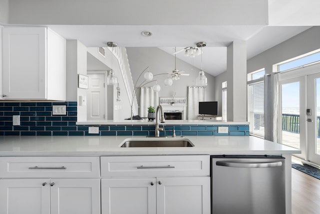 23401 Termini San Luis Pass Rd, Galveston, TX 77554 - kitchen with stainless steel dishwasher, a sink, lofted ceiling, white cabinetry, and light countertops