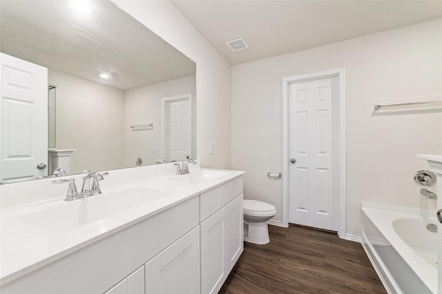 5810 Dry Brush Pl, Katy, TX 77493 - bathroom featuring toilet, wood finished floors, a bathtub, double vanity, and baseboards