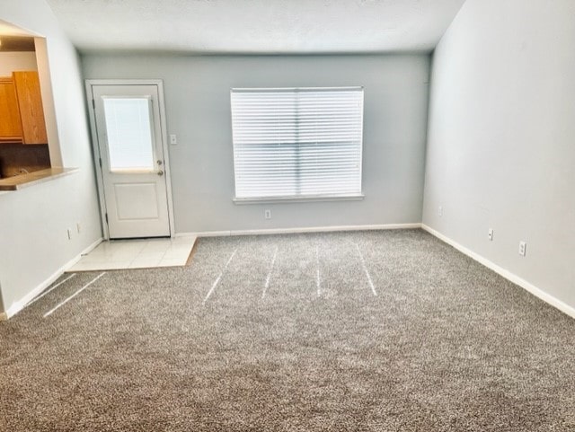 4938 Winding View Ln, Humble, TX 77346 - unfurnished living room featuring carpet floors and baseboards