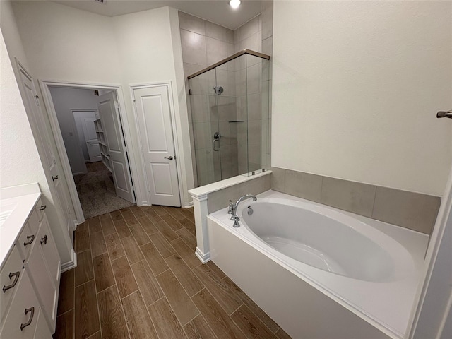 208 Cider Gum Pl, Montgomery, TX 77316 - full bath with a shower stall, vanity, a garden tub, and wood finished floors