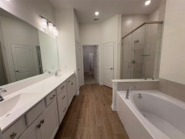 208 Cider Gum Pl, Montgomery, TX 77316 - bathroom with a shower stall, a garden tub, wood finished floors, double vanity, and recessed lighting